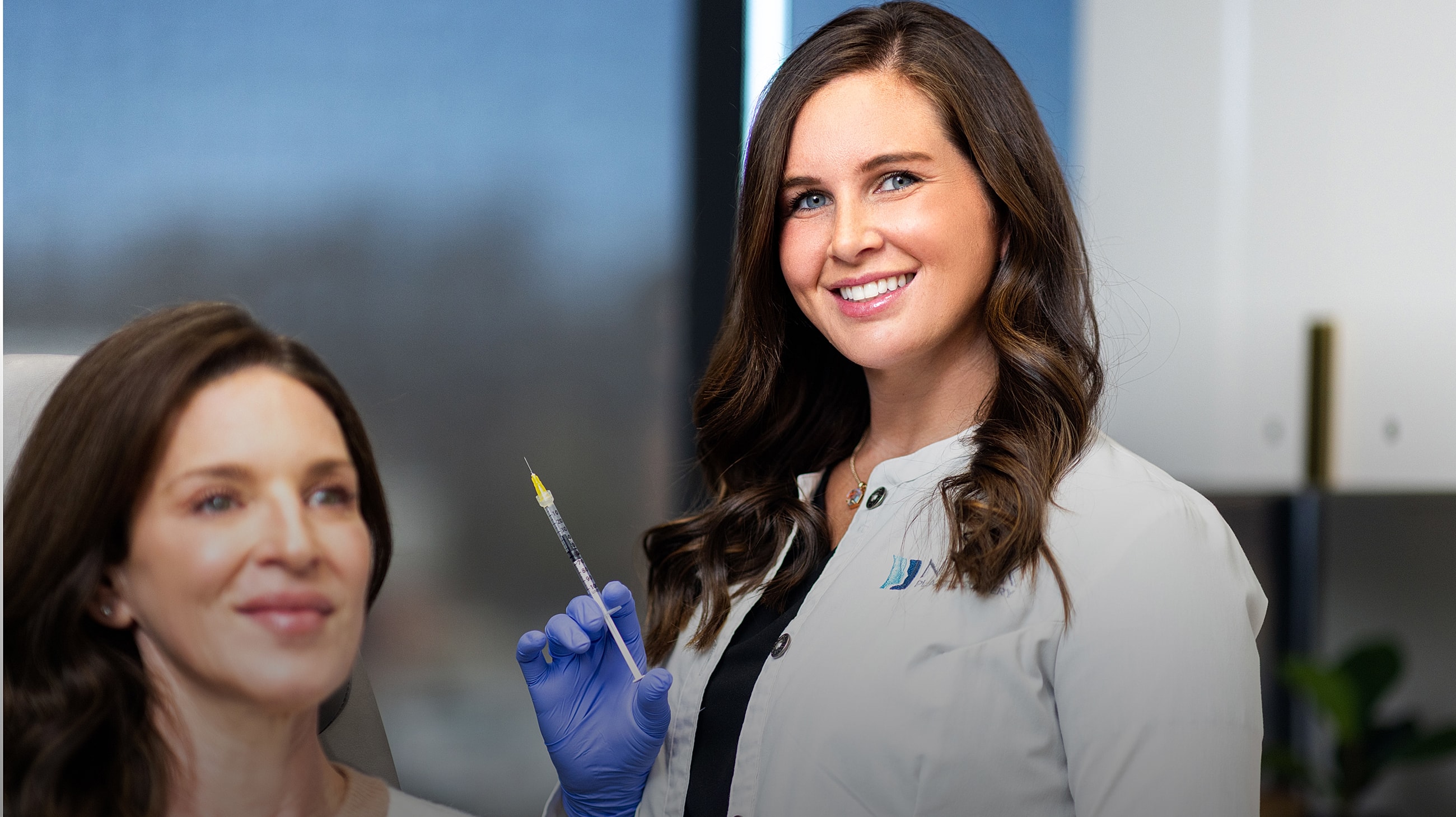 Doctor in scrubs smiling in a medical office.