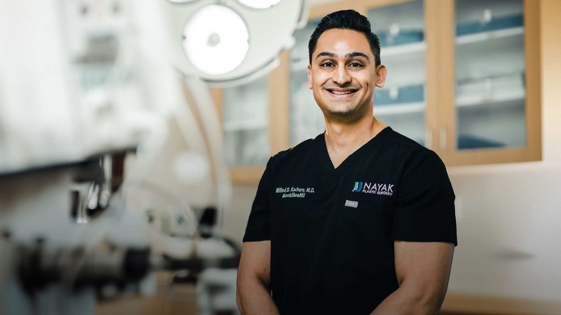 Smiling doctor in surgical attire, healthcare setting.