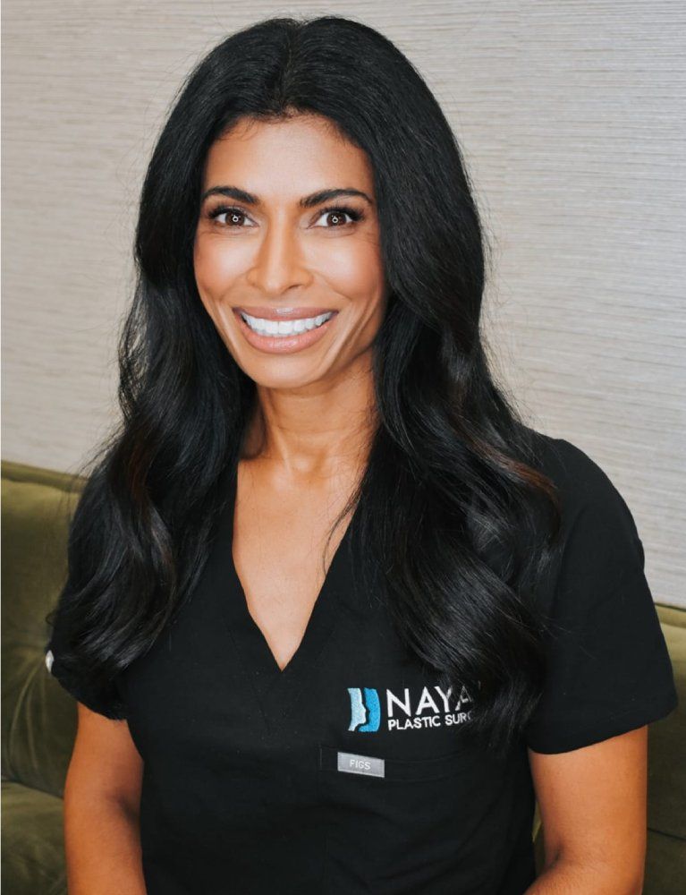 Smiling professional in black medical scrubs.
