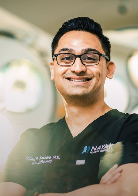 Smiling male healthcare professional in surgical attire.