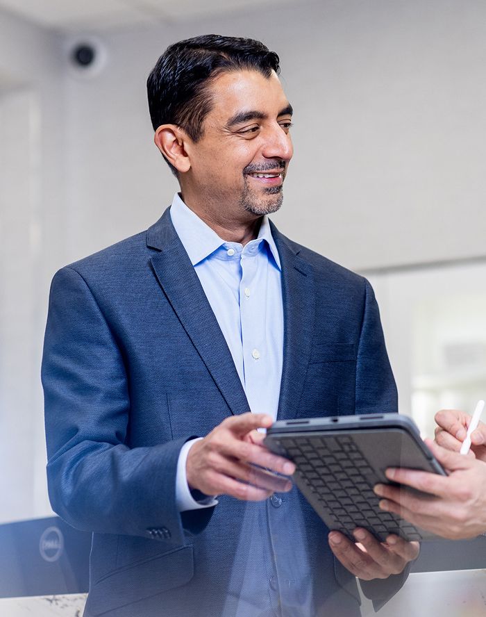 St. Louis facial plastic surgery provider, Dr. Nayak discussing tablet with colleague in office.
