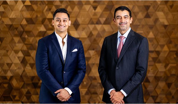 Two men in formal attire posing together.