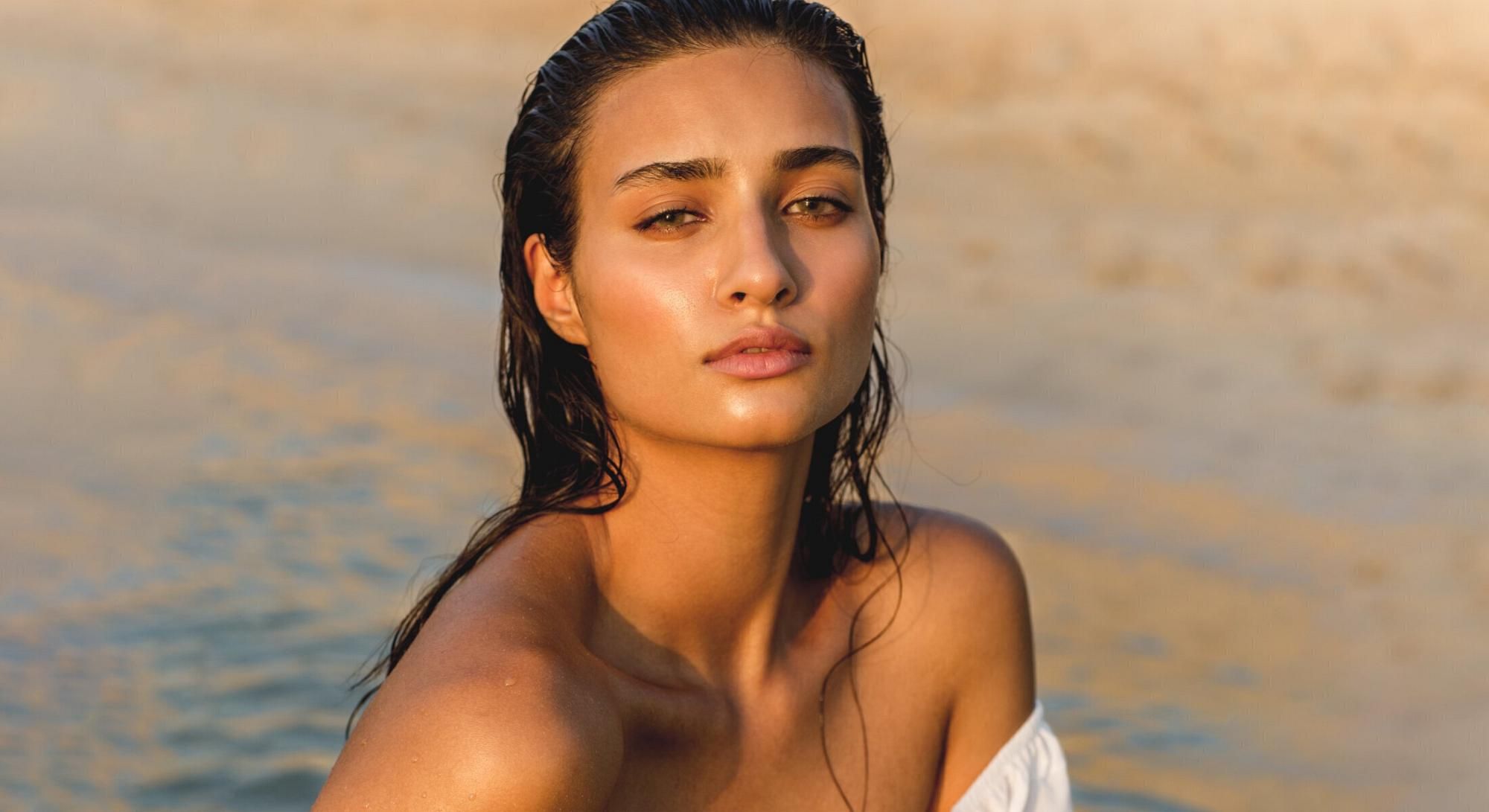 Young woman with wet hair by the beach.