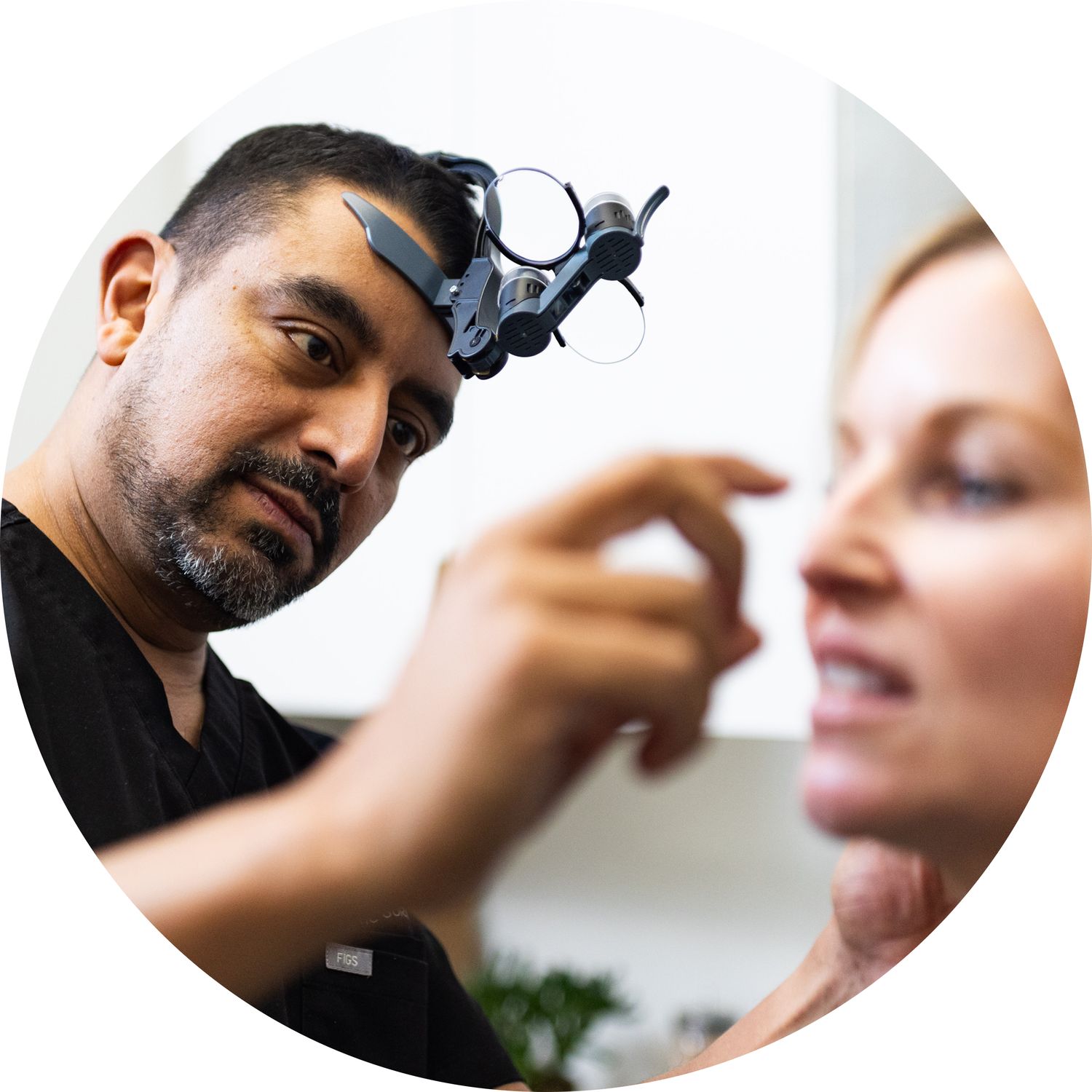 Medical professional examining a patient's face.