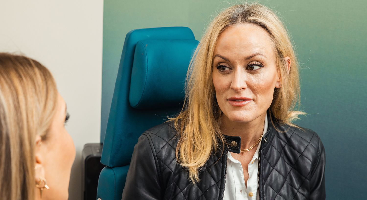 Woman in conversation, focused expression, casual setting.